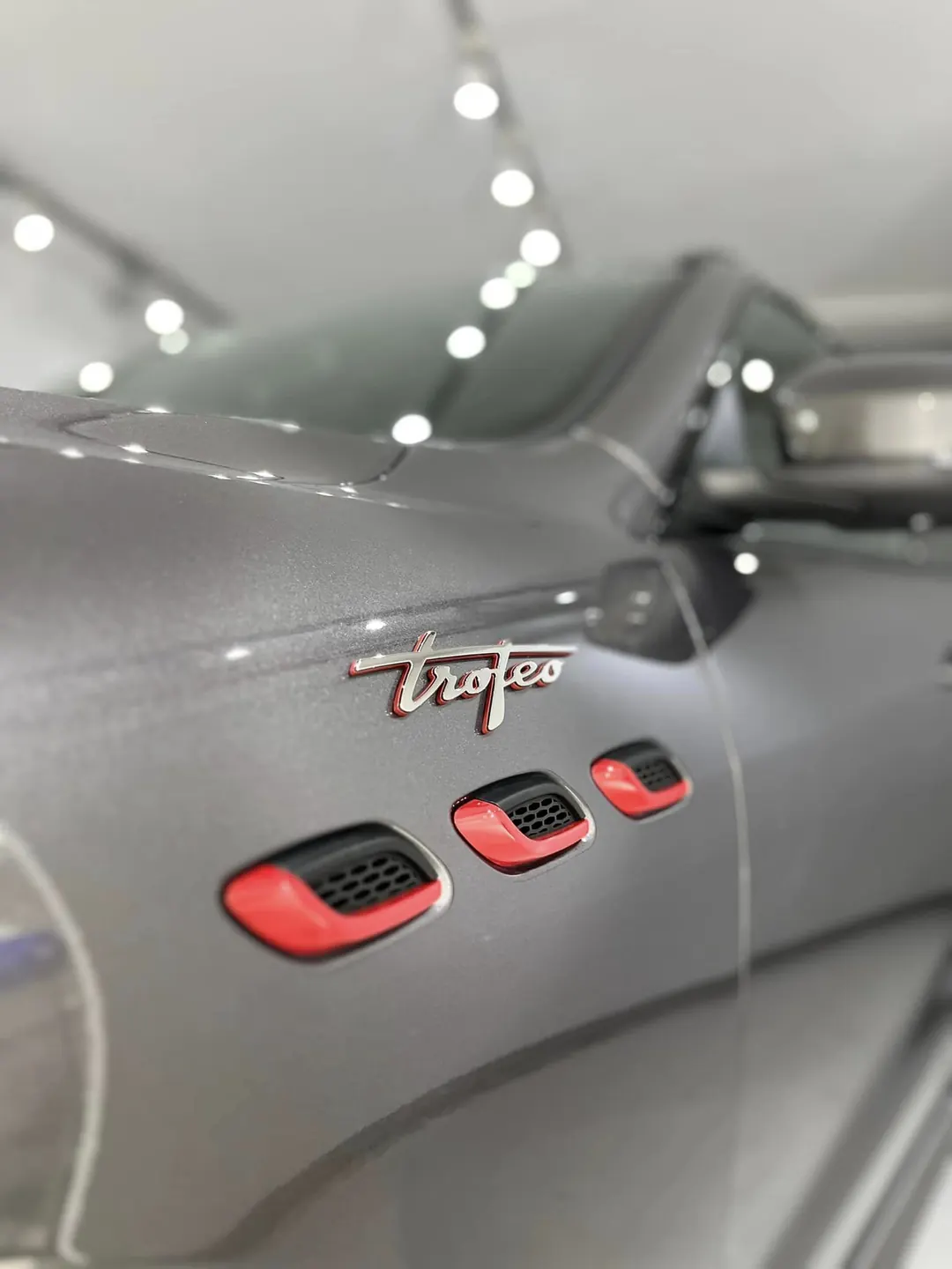Detalj av Maserati Trofeo-emblem på blank lakk